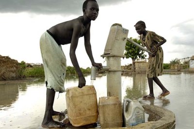 Displaced children fetch water using a submerged hand pump following flooding in the villages caused by extremely heavy rains.(file photo).
