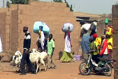 Residents in the the Nasarawa Gown area of Jos in Plateau State flee for safety.