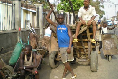 Unemployed youths in Sierra Leone sometimes find work pushing wooden carts for merchants (file photo).