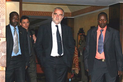 International Criminal Court Prosecutor Luis Moreno-Ocampo (centre) , with his security team, leaves the Serena Hotel for a meeting with a Cabinet sub committee on the investigations at Harambee House on May 10,2010.