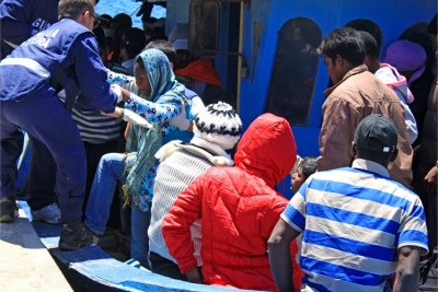 Coastguards help a woman off a boat arriving in Lampedusa from Libya (file photo).