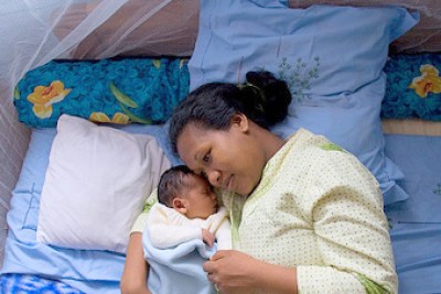 Une femme et son bébé protégés par une moustiquaire imprégnée.