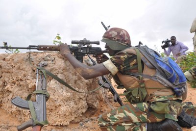 An African Union soldier takes position during fierce clashes with Al Shabaab fighters
