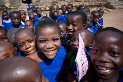 A group of children gather outside for a portrait at the Young Tajudeen Agbangudu Primary School in Nigeria.