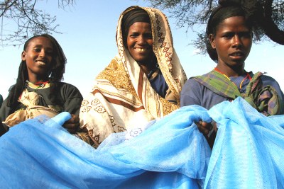 Women in Ethiopia receive free bed nets.