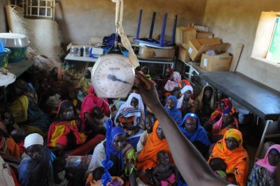 Women watch as their children are being weighed at MSF's Ambulant Therapeutic Feeding Center in Chad.
