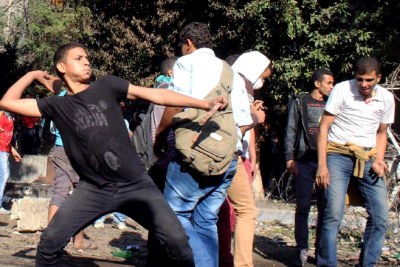 An Egyptian protester hurls stones at riot police during clashes (file photo).