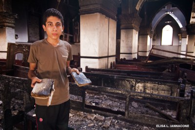 A church member holds prayer book at a burnt-out church (file photo).