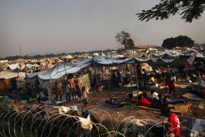 Des enfants et des adultes déplacés s’abritent à l’extérieur d’une clôture de barbelés, dans un camp mis en place derrière l’aéroport international Mpoko de Bangui, en République centrafricaine (RCA). - (Archive)