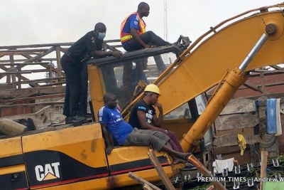 Nigerian Police Force officer rides on excavator on morning of 19 Sept 2015.