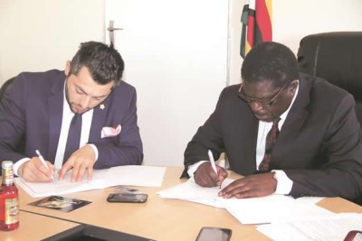 Industry and Commerce Minister Mike Bimha (right) signs a Memorandum of Understanding with the president of El Badaoui Group.