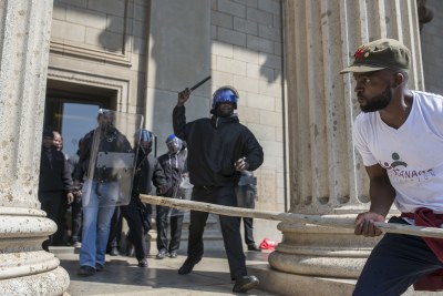 A student from the University of Witwatersrand (WITS) tries to break through a barricade formed by private security guards.