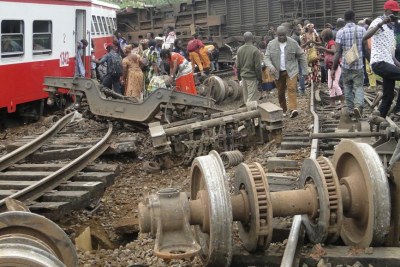 Angry family members of the victims of a train crash search through the wreckage.