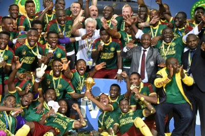 Cameroon team players and Cameroon's Belgian coach Hugo Broos (C) celebrate after beating Egypt 2-1 to win the 2017 Africa Cup of Nations final.
