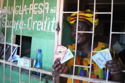 Bangla-Pesa grassroots coordinator Emma Onyango displays different notes of the currency at her shop in Bangladesh, Mombasa, on May 10, 2017.