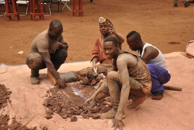 Miners searching for gold from the dust collected from a gold pit in Kasanda-Mubende