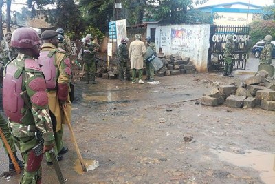 La police anti-émeute enlève des pierres à l'entrée de l'école primaire olympique, au Kenya, le 27 octobre 2017.