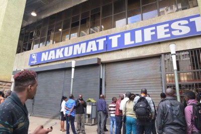 Employees and bystanders mill around the entrances to Nakumatt Lifestyle branch on Hazina Towers in Nairobi after it was shutdown on December 22, 2017 over unpaid rent arrears.