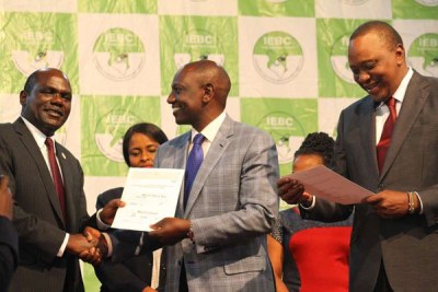 IEBC chairman Wafula Chebukati (left) presents Deputy President William Ruto with a certificate after Uhuru Kenyatta was declared winner of the presidential election, at the Bomas of Kenya on October 30, 2017.