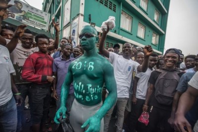 A supporter of Julius Maada Bio and the Sierra Leone People's Party wears green paint, the party's color, outside of SLPP headquarters in Freetown, Sierra Leone.
