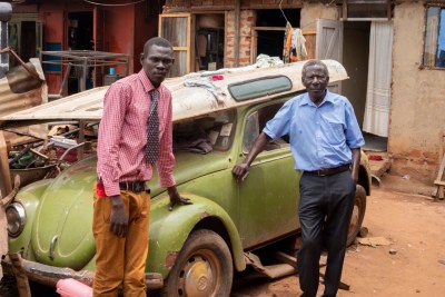 Louis Lakor, left, founder of the Baka Youth Training Centre, and Peter Owiny Mwa, nicknamed Baka, Louis' former boss, pose for a photo in Gulu, Northern Uganda, March 29, 2018.