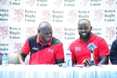 Kenya Sevens coach Innocent Simiyu (left) and his Lionesses counterpart Kevin Wambua enjoy a light moment after naming their teams for Hong Kong, Singapore and Commonwealth Games on March 28.