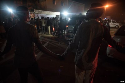 Protesters hold hands to create a cordon to create space for ambulances and other vehicles transporting wounded to hospital.