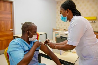 At Nizamiye Hospital, a private facility in Abuja, a nurse administers a second COVID-19 dose to a recipient.