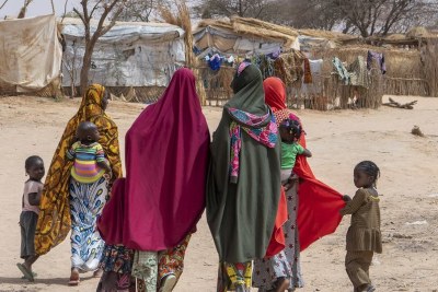 Une famille déplacée marche dans un camp de fortune à Ouallam, au Niger.