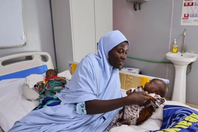 Zarah takes care of her five-month old twins who are receiving treatment for malnutrition at the Nilefa Kiji nutrition centre in Maiduguri. Nigeria, April 2023.