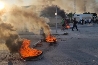 Young Tunisians burn tires after the funeral of a young man stabbed to death during clashes with sub-Saharan migrants, in Sfax, July 4, 2023