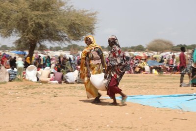 Women who have fled Sudan's conflict receive WFP food assistance in Zabout Refugee camp in Chad.